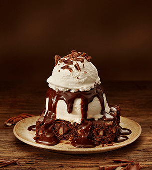 Doce Chocolate Thunder From Down Under - sorvete com cobertura de chocolate em cima de um brownie.