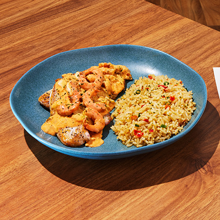 Prato com peixe, servido com camarões e arroz.
