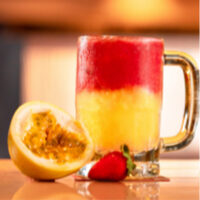 Caneca com suco MaraMora, com um maracujá aberto e morango ao lado.