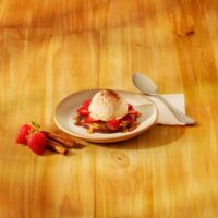 Uma sobremesa com base crocante de biscoito Thunder, doce de leite e calda de caramelo. Finalizada com morangos frescos, sorvete sabor baunilha e um toque de canela.