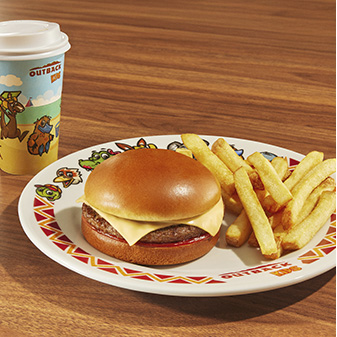 Cheeseburger com fritas, servido em prato decorado sobre uma mesa de madeira.